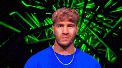 Man In Blue Shirt And Chain Looking At Camera GIF