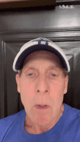 Man in Blue Shirt and Hat With T