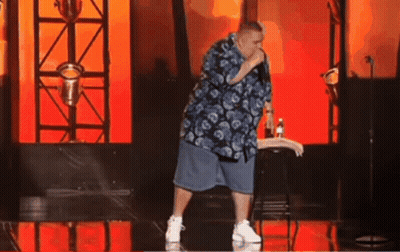 Man In Blue Shirt And Shorts Holding Microphone On Stage GIF