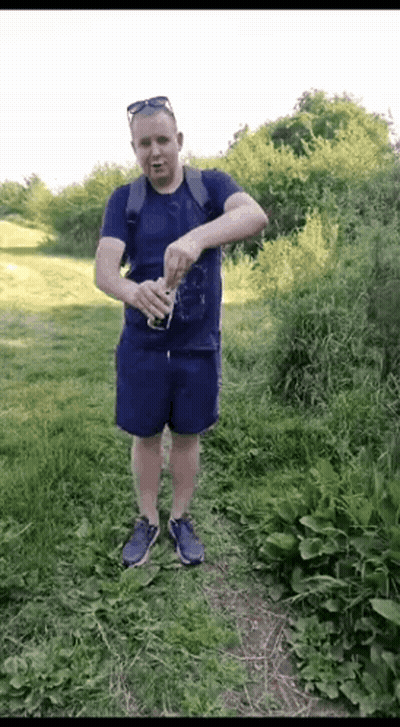 Man In Blue Shirt And Shorts Holding Soda GIF