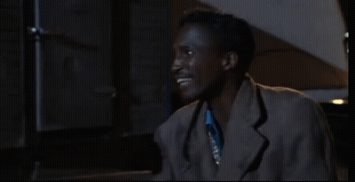Man In Blue Shirt And Silver Vest Smiling GIF