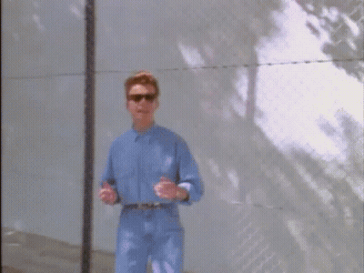 Man In Blue Shirt And Sunglasses At Fence GIF