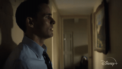 Man In Blue Shirt And Tie In Hallway With Disney Logo GIF