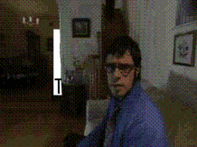 Man In Blue Shirt And Tie Standing In Dark Room With T GIF