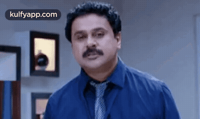 Man In Blue Shirt And Tie Standing In Room GIF