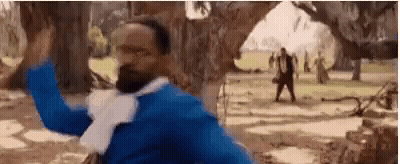 Man In Blue Shirt And White Scarf Standing In Park GIF
