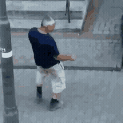 Man In Blue Shirt And White Shorts Walking On Street GIF