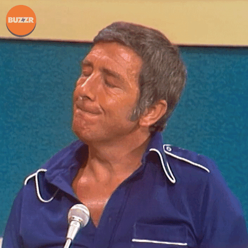 Man In Blue Shirt At Microphone With Buzzr Logo GIF