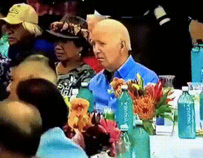 Man In Blue Shirt At Table With Flowers And Aquafina Bottles GIF