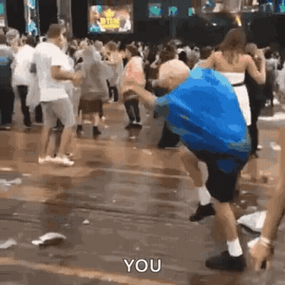 Man In Blue Shirt Dancing In Rain With Crowd GIF