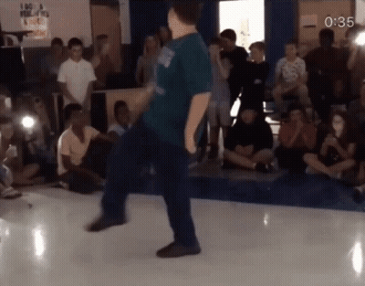 Man In Blue Shirt Dancing With Sign I Am A Filipino GIF