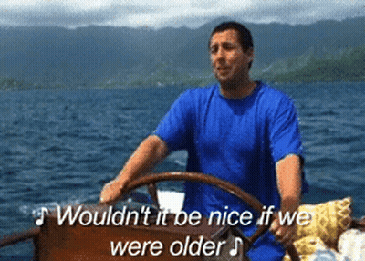 Man In Blue Shirt Driving Boat Saying Wouldn't It Be Nice If We Were Older GIF