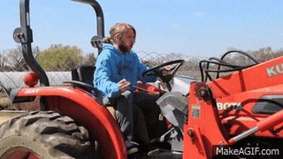 Man In Blue Shirt Driving Red Kubota Tractor GIF