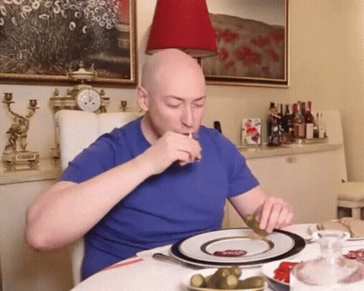 Man In Blue Shirt Eating Pickles GIF