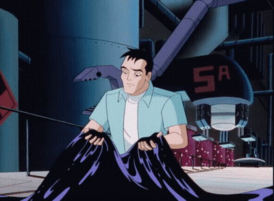 Man In Blue Shirt Holding Black Object In Front Of Machine With Letters SA GIF