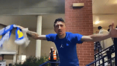Man In Blue Shirt Holding Blue And Yellow Scarf GIF