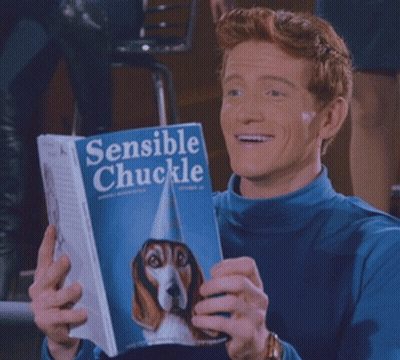 Man In Blue Shirt Holding Book Sensible Chuckle GIF