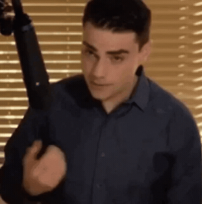 Man In Blue Shirt Holding Gun GIF