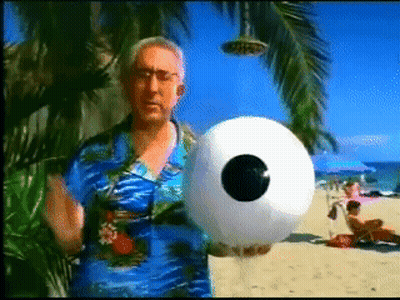 Man In Blue Shirt Holding Inflatable Ball With Eye GIF