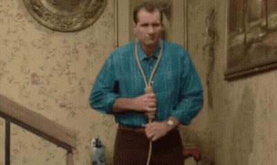 Man In Blue Shirt Holding Rope Around Neck On Stairs GIF