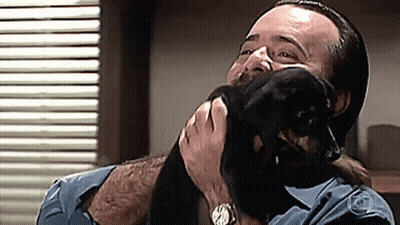 Man In Blue Shirt Holding Small Black Dog GIF
