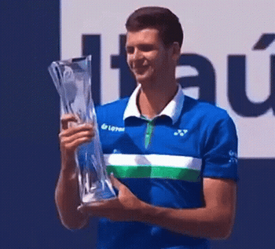 Man In Blue Shirt Holding Trophy And Smiling GIF