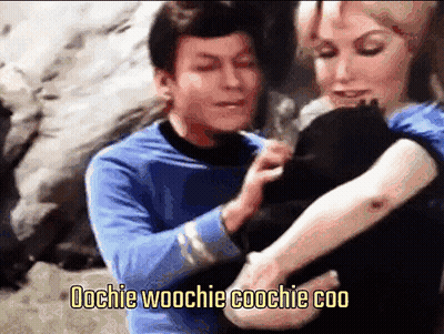 Man In Blue Shirt Holding Woman's Arm Saying Oochie Woochie Coochie Coo GIF