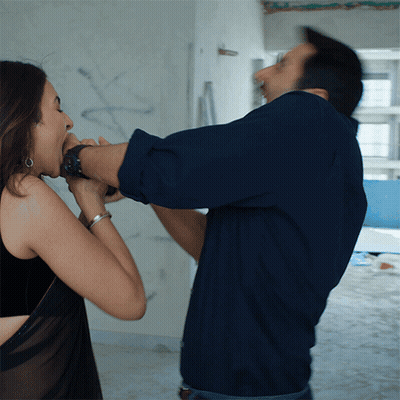 Man In Blue Shirt Holding Woman's Mouth GIF