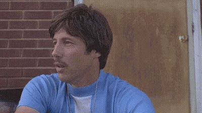 Man In Blue Shirt How Much You Wanna Bet I Could Throw A Football Over Them Mouthains GIF