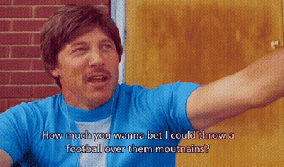 Man In Blue Shirt How Much You Wanna Bet I Could Throw A Football Over Them Mouthains GIF