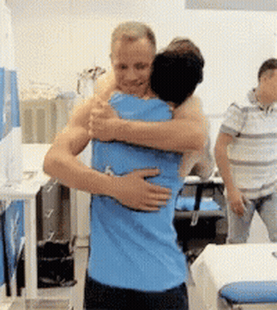 Man In Blue Shirt Hugging Another Man In Hospital GIF