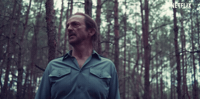Man In Blue Shirt In Forest With Netflix Logo GIF