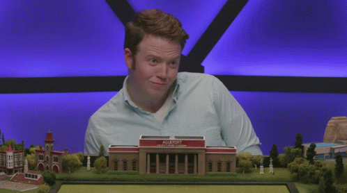Man In Blue Shirt In Front Of Agleport College Model GIF