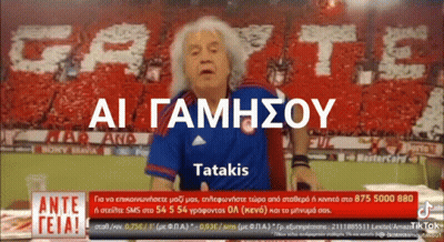 Man In Blue Shirt In Front Of AI Gamhsou Tatakis Banner GIF