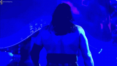 Man In Blue Shirt In Front Of Blue Light GIF