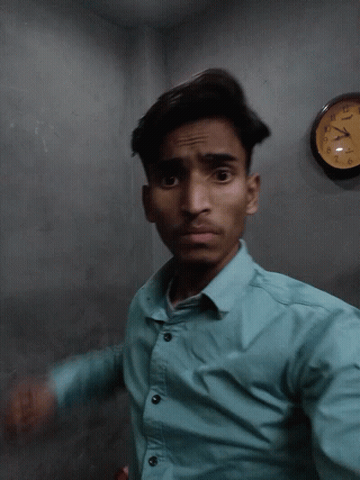 Man In Blue Shirt In Front Of Casio Clock GIF