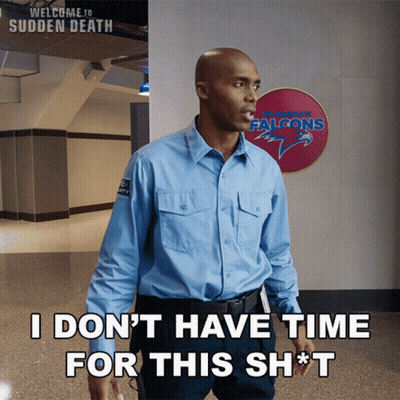 Man In Blue Shirt In Front Of Falcons Sign GIF