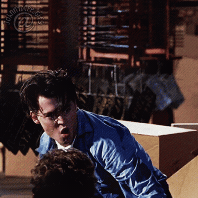 Man In Blue Shirt In Front Of Johnny Depp Sign GIF