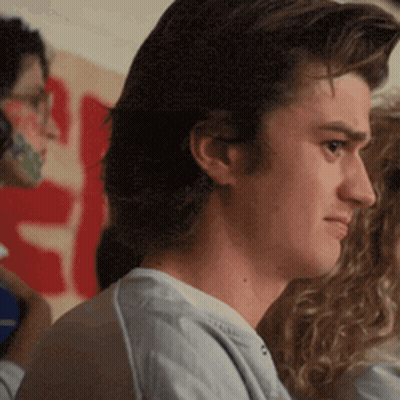 Man In Blue Shirt In Front Of S Sign GIF