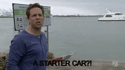 Man In Blue Shirt In Front Of Starter Car Sign GIF