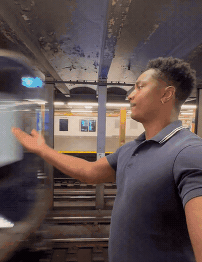 Man In Blue Shirt In Front Of Subway Train GIF