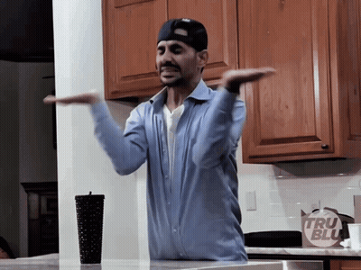 Man In Blue Shirt In Front Of Tru Blue Bag GIF