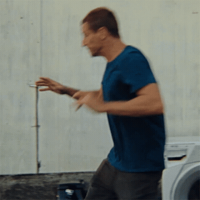 Man In Blue Shirt In Front Of Washing Machine GIF