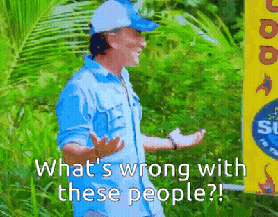 Man In Blue Shirt In Front Of What's Wrong With These People Sign GIF