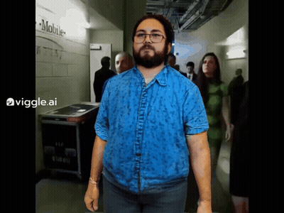 Man In Blue Shirt In Hallway With Mobile Sign GIF