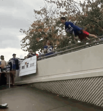 Man In Blue Shirt Jumping Over Juice Sign GIF