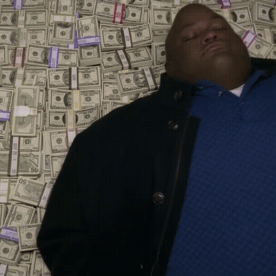 Man In Blue Shirt Laying In Pile Of Money With 50 Bill GIF
