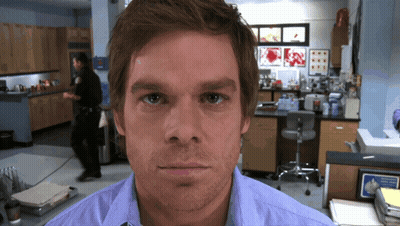 Man In Blue Shirt Looking At Camera GIF