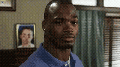 Man In Blue Shirt Looking At Camera With Woman Picture In Background GIF