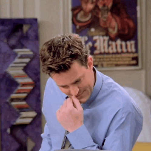 Man In Blue Shirt Looking Down In Front Of Le Matua Poster GIF